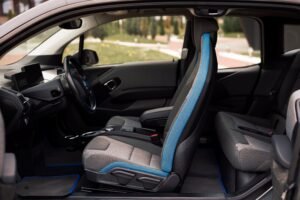 A sleek interior of a modern car showcasing the front and rear seats and steering wheel details.