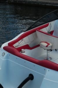 Close-up of luxury boat interior featuring red and white seats by the water.