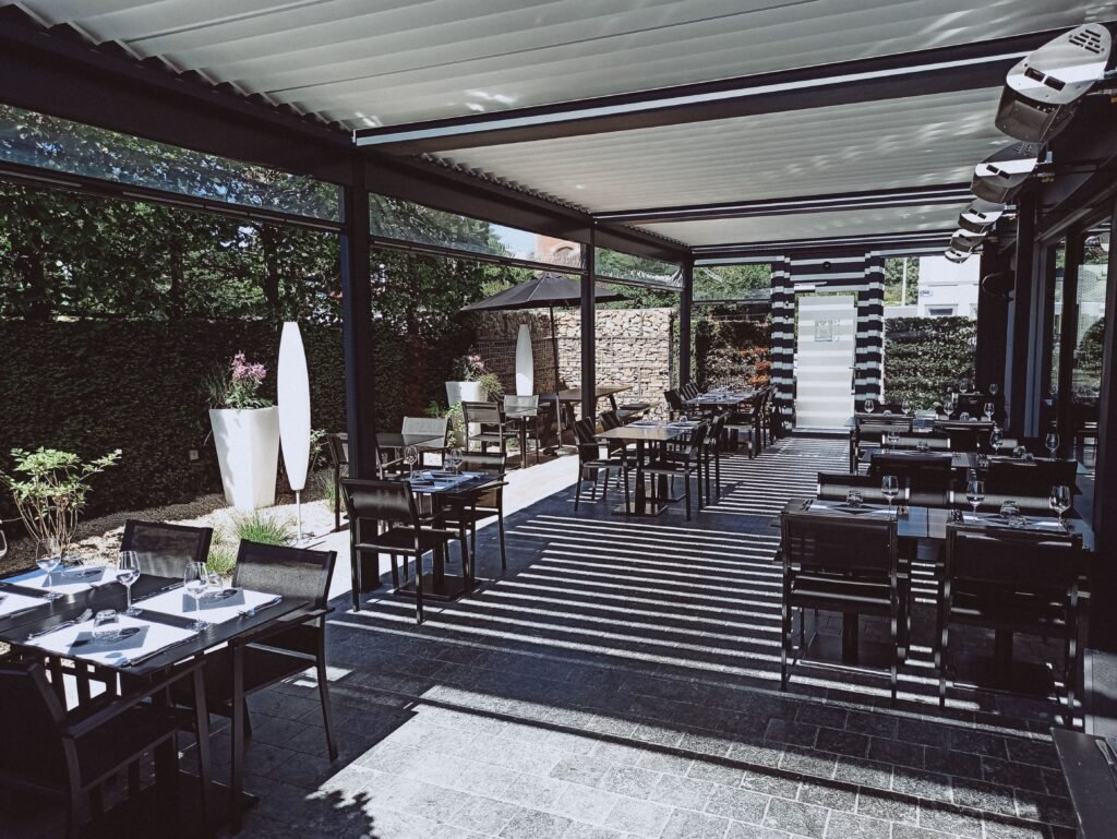 pexels photo 4831062 4831062 Spacious outdoor dining area with tables, chairs, and ambient lighting.